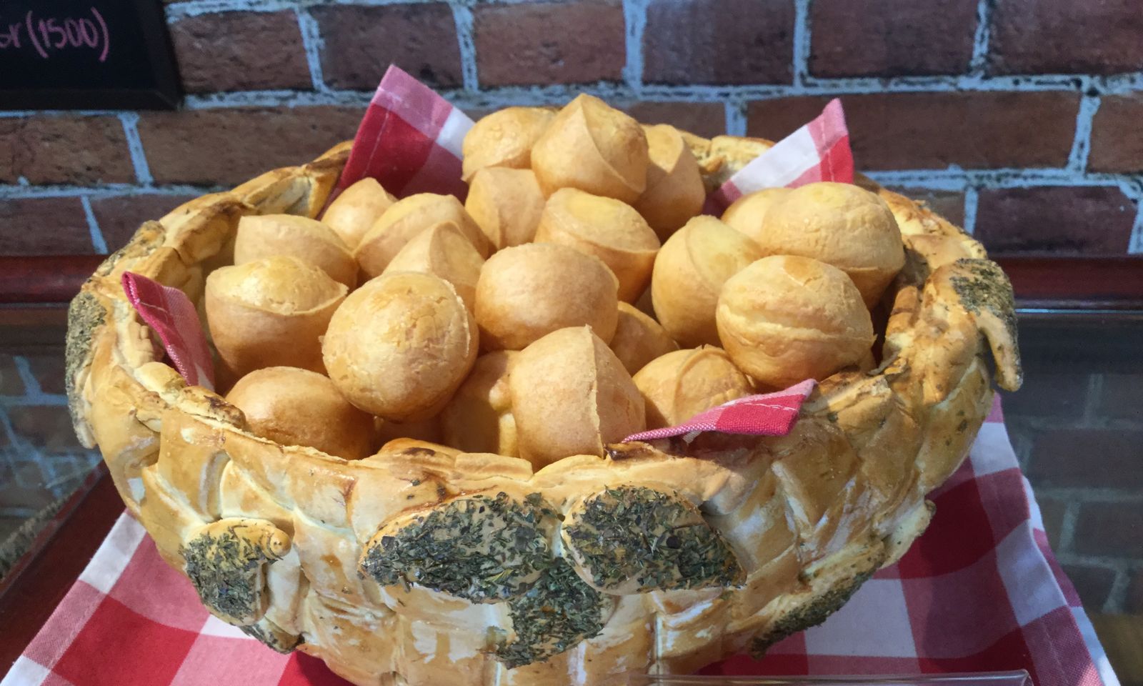 Canasta de pan rellena de pimpones sobre un mantel de cuadros rojos y blancos